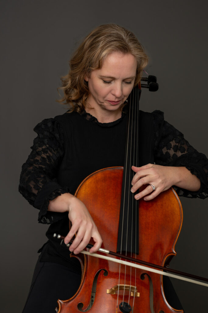 Dorothy Olsen with cello, representing her music performance and teaching background.